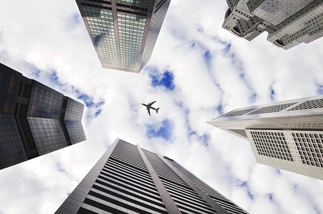 Are you planning on moving to New York from abroad? Airplane Over Skyscrapers image